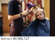 Hair salon, hairdresser dries hair with hair dryer for kid in barber shop at mirror. Barber woman make hairstyle for cute little blonde girl in barbershop. Haircare, beauty concept. Copy ad text space. Стоковое фото, фотограф Aleksandr Golubev / Фотобанк Лори