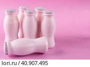 Бутылочки молочного йогурта (кефира) стоят на розовом фоне. Концепция пробиотиков (бифидобактерий). Место для текста. Стоковое фото, фотограф Айгуль Миннибаева / Фотобанк Лори
