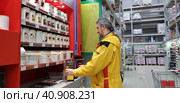 Buyer selects paint and plaster in the store (2018 год). Редакционное фото, фотограф Анна Кривицкая / Фотобанк Лори