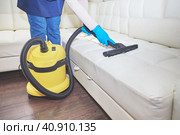 Girl vacuuming sofa indoors industrial vacuum cleaner. Стоковое фото, фотограф Стас Пересыпкин / Фотобанк Лори