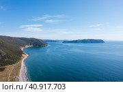 Красивая аэрофотосъемка морского побережья. Вид сверху на побережье и гористый остров. Голубая вода и небо. Природа Сибири и Дальнего Востока России. Охотское море, Магаданская область, Россия. Стоковое фото, фотограф Андрей Степанов / Фотобанк Лори