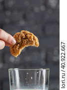 Female hand dunking cookie in milk close up. Стоковое фото, фотограф Сергей Толмачёв / Фотобанк Лори