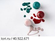 Bright colored nail polish bottles with drippings on white background. Стоковое фото, фотограф Сергей Толмачёв / Фотобанк Лори