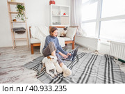 Relaxing young woman using laptop in living room. Стоковое фото, фотограф Гладских Татьяна / Фотобанк Лори