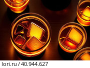 Two orange campari cocktails (Old-Fashioned Negroni Aperol Spritz) with ice on a contrast turquoise background, vertical. Light through the liquid. Top down view. Generative AI. Стоковое AI-изображение, AI-художник Sergey Grishin / Фотобанк Лори