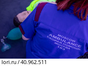 Надпись "Скорая помощь" на спине врача, сотрудника скорой помощи в городе Москве, Россия (2023 год). Редакционное фото, фотограф Николай Винокуров / Фотобанк Лори