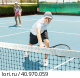 Man in shorts and t-shirt playing tennis on court. Racket sport training outdoors. Стоковое фото, фотограф Яков Филимонов / Фотобанк Лори