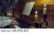 A woman plays the piano in the light of candles and kerosene lamp. Стоковое видео, видеограф Сергей Медведев / Фотобанк Лори