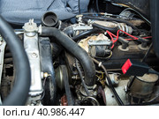 Fixing an old van`s engine malfunction. Motor cover is demounted in order to get an access to the inner details. Repairing and fixing concept. Technical inspection. Устраняем неисправность двигателя старого фургона. Крышка двигателя установлена таким образом, чтобы обеспечить доступ к внутренним деталям. Концепция ремонта и закрепления. Технический осмотр. Стоковое фото, фотограф Дмитрий Березнев / Фотобанк Лори