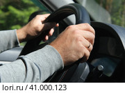 Male Hands holding steering wheel close up. Confident man driving a car during jorney trip. Side view from passenger inside car interior. Summer day. Driver. Selective Focus, Cropped. Travel concept. Стоковое фото, фотограф Марина Демидюк / Фотобанк Лори