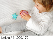 Cute baby girl playing tactile knobby balls. Young child hand plays sensory massage ball. Enhance the cognitive, physical process. Brain development. Support for Children with ADHD, autism, fidgeting. Стоковое фото, фотограф Марина Демидюк / Фотобанк Лори