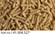 Gluten Free Cornmeal Pasta Wallpaper. Spiral Raw Macaroni from Corn and Rice flour rotating on Turntable. Close Up Top View. Uncooked Pasta Spinning. Full Frame. Food Background. Fusilli Bucati Corti. Стоковое видео, видеограф Марина Демидюк / Фотобанк Лори