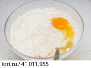 Preparation of the yeast dough. Dough with the egg`s yolk and flavour in the glass bowl is ready to be stirred. Приготовление дрожжевого теста. Тесто с яичным желтком и ароматизатором в стеклянной миске готово к перемешиванию. Стоковое фото, фотограф Дмитрий Березнев / Фотобанк Лори