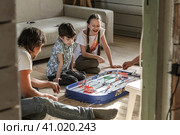 Дети смеются наблюдая как взрослые играют на полу в хоккей (2012 год). Редакционное фото, фотограф Elena Kotova / Фотобанк Лори