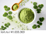 Moringa leaves and moringa powder on the table. Стоковое AI-изображение, AI-художник Ольга Ильина / Фотобанк Лори