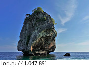 The rocky island rises above the turquoise Andaman Sea, against a backdrop of blue sky. Several trees grow on steep slopes. Thailand. Koh Ha Islands. Стоковое фото, фотограф Вера Ивановна Кубарева / Фотобанк Лори