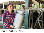 Female farmer carrying milk churn at dairy farm. Стоковое фото, фотограф Яков Филимонов / Фотобанк Лори