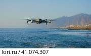 Remote controlled unrecognizible drone flies over water. High resolution video camera flying above t. Стоковое видео, видеограф Ольга Сухарева / Фотобанк Лори
