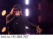 Музыкант, лидер рок-группы "СерьГа" Сергей Галанинво время выступления на сцене стадиона спортивного комплекса Лужники в День флага России, в городе Москве, Россия (2023 год). Редакционное фото, фотограф Николай Винокуров / Фотобанк Лори