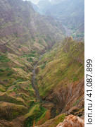 Breathtaking view of canyon with steep cliff and winding riverbed with lush green vegetation on Delgadinho mountain ridge. Santo Antao, Cape Verde. Стоковое фото, фотограф Igor Tichonow / Фотобанк Лори
