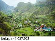 Gorgeous panorama view of a fertile Paul valley. Agriculture terraces of sugarcane in vertical valley sides, dwellings, rugged peaks and motion clouds on horizon. Стоковое фото, фотограф Igor Tichonow / Фотобанк Лори