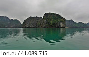 Tropical islands with steep slopes are shrouded in fog. Reflection on the smooth emerald water of Halong Bay. Vietnam. Стоковое фото, фотограф Вера Ивановна Кубарева / Фотобанк Лори