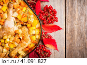 Осеннее блюдо. Запеченная курица с осенними овощами, картофелем, тыквой и морковью в стеклянной емкости. Вид сверху. Стоковое фото, фотограф Андрей Пустякин / Фотобанк Лори