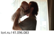 Young neo father is playing with his newborn baby in a nursery morning. Father's Day. Father holds in hands little Child and Plays with him. Concept of children, baby, parenthood, childhood, family. Стоковое видео, видеограф Марина Демидюк / Фотобанк Лори