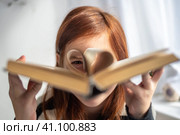A girl is holding a book. Heart-shaped pages. Reading, Knowing, Learning. Стоковое фото, фотограф Ольга Ильина / Фотобанк Лори