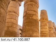 Colonnade in the hypostyle hall of the Karnak Temple of Luxor. Tall ancient columns against the blue sky. Carvings and hieroglyphs are visible. Close-up. Egypt (2021 год). Стоковое фото, фотограф Вера Ивановна Кубарева / Фотобанк Лори