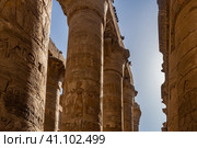 The colonnade of the hypostyle hall of the Karnak Temple against the blue sky. A row of columns with carved drawings, hieroglyphs. Egypt. Luxor. (2021 год). Стоковое фото, фотограф Вера Ивановна Кубарева / Фотобанк Лори