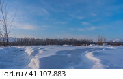 The path is trampled in snowdrifts. Snow sparkles in the sun. A winter forest is visible ahead against the blue sky. Altai. Стоковое фото, фотограф Вера Ивановна Кубарева / Фотобанк Лори