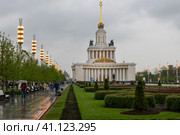 Вид Центральной аллеи Выставки достижений народного хозяйства ВДНХ (ВВЦ) и Павильон № 1 Центральный дождливым весенним днем (2016 год). Редакционное фото, фотограф Pukhov K / Фотобанк Лори