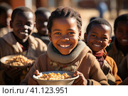 The problem of poverty and inequality. Happy african kids eating some sorghum porridge in village outdoor. Стоковое AI-изображение, AI-художник Ирина Михайличенко / Фотобанк Лори