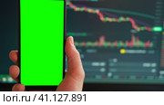 Black phone with blank mockup screen on rising stock graph. Closeup hand showing smartphone isolated green display. Online banking, Fund App use. Financial analyst on Invest Market. Bank collapse 2023. Стоковое видео, видеограф Марина Демидюк / Фотобанк Лори