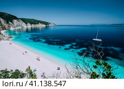 Panoramic view to remote beach wiht lonely white catamaran yacht drift in clear blue Caribbean like sea water. Tourists leisure activity on the beach with azure colored shallow lagoon (2018 год). Стоковое фото, фотограф Igor Tichonow / Фотобанк Лори