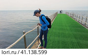 People play with jellyfish along the pier stretching into the Black Sea. Стоковое видео, видеограф Станислав Типляшин / Фотобанк Лори