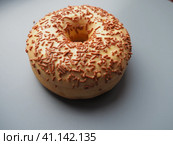 A doughnut or donut. A type of leavened fried dough. Sweet snack that can be homemade or purchased in bakeries, supermarkets, food stalls. Delicious pie with light icing on gray background. Стоковое фото, фотограф Юлия Петровская / Фотобанк Лори