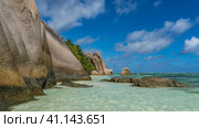 Coastal granite rocks with smoothed steep slopes against a blue sky and clouds. Picturesque boulders in the clear turquoise ocean water. Seychelles. La Digue. Anse Source D’Argent beach (2022 год). Стоковое фото, фотограф Вера Ивановна Кубарева / Фотобанк Лори