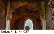 Details of the architecture of the ancient temple complex Qutub Minar. The arches of the sandstone building are decorated with carvings. The blue sky is visible in the opening. India. Delhi (2022 год). Стоковое фото, фотограф Вера Ивановна Кубарева / Фотобанк Лори