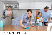 Smiling woman cleaning apartment together with husband and daughters. Стоковое фото, фотограф Яков Филимонов / Фотобанк Лори