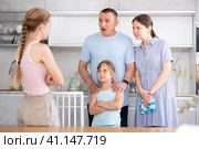 Disgruntled parents reprimanding eldest teenage girl in home kitchen. Стоковое фото, фотограф Яков Филимонов / Фотобанк Лори