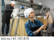 Woman brewmaster measuring beer with alcoholometer. Стоковое фото, фотограф Яков Филимонов / Фотобанк Лори