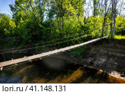 Деревянный подвесной мост через речку Линда. Стоковое фото, фотограф Илья Старков / Фотобанк Лори
