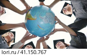 Graduating students twirl a geographic globe of the world in their hands. Стоковое видео, видеограф Mikhail Davidovich / Фотобанк Лори