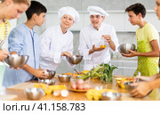 Man and woman cooks, during culinary master class, tell children rules when preparing dough. Стоковое фото, фотограф Яков Филимонов / Фотобанк Лори