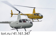 White Robinson R44 flies and dangerously overtakes flying yellow Robinson R44 in close proximity (2023 год). Редакционное видео, видеограф А. А. Пирагис / Фотобанк Лори