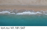 Top down view of sandy beach and turquoise sea waves at shore edge. Стоковое фото, фотограф Igor Tichonow / Фотобанк Лори