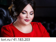 Plus size fashion model in red dress with professional make-up and hairstyle. Стоковое фото, фотограф Станислав Тарко / Фотобанк Лори