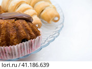 Sweets for tea and coffee, a cake with rum covered with chocolate and a sweet tube with custard. Selective focus. Copy space. Сладости к чаю и кофе, торт с ромом, покрытый шоколадом, и сладкая трубочка с заварным кремом. Избирательный фокус. Пространство для копирования. Стоковое фото, фотограф Дмитрий Березнев / Фотобанк Лори